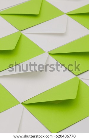 Composition with white and green envelopes on the table.