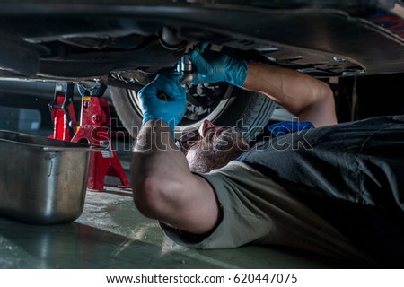 mechanic fixing a car at home	 Royalty-Free Stock Photo #620447075