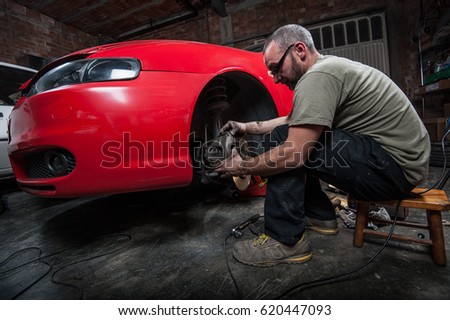 mechanic fixing a car at home	 Royalty-Free Stock Photo #620447093