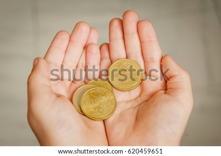 Child holding coins in his hands. Pocket money stock image. Poor low income family, poverty concept.
