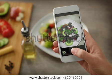 Female hand photographing food with smart phone