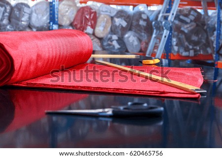 roll of red material lying on the cutting table in the Studio on tailoring of textiles
