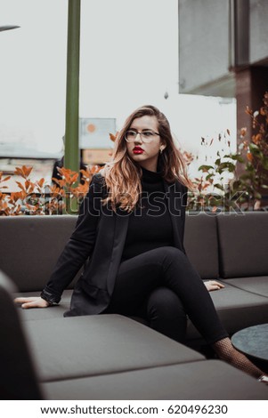 Young businesswoman sitting with vintage and elegant dress in a bar. Lifestyle