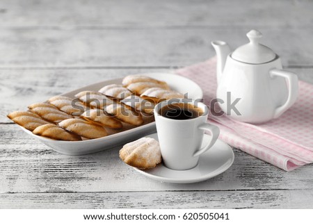 Homemade vanilla cookies Madeleine with a cup of coffee on a wooden background. Holidays food.