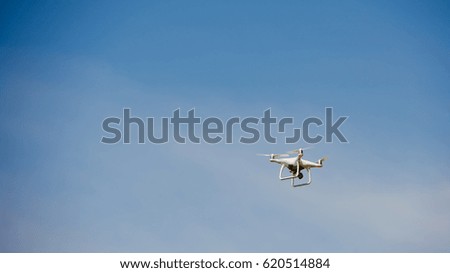 White drone in the air against the blue sky. Background for a postcard.