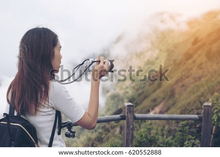 woman hiker taking photo with digital camera at mountain.