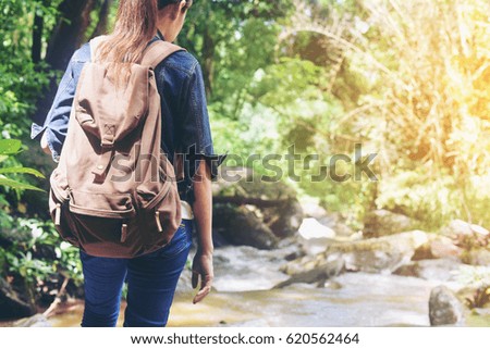 young woman backpacker hiking on forest.