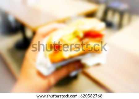 Picture blurred abstract background of hand hold burger