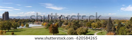 Panorama of Denver City Park with skylines and rocky mountains in the background.