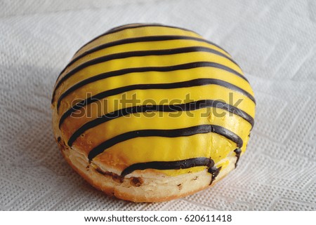 Toasted delicious yellow with black strips donut