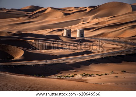 Liwa, Abu Dhabi, UAE-February 2, 2016: A view of Liwa desert and road along the Empty Quarter before sunset in Abu Dhabi, United Arab Emirates on February 2, 2016 Royalty-Free Stock Photo #620646566