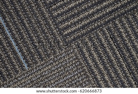 Gray carpet swatch with straight line patterns with four intersecting lines.