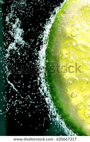 slice of lime in soda bubbling 