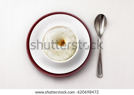 Coffee cappuccino in a white cup on a white plate with a brown border on a white background. view from above