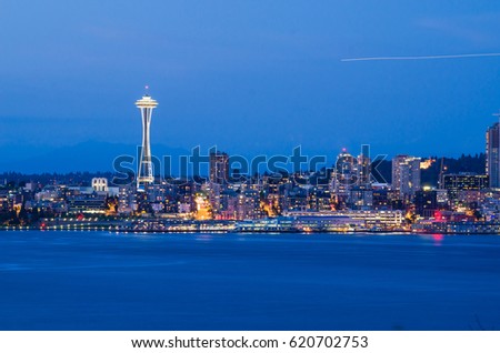 View of Seattle downtown with Space Needle iconic from Alki Beach at blue hour .
