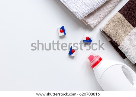Pile of pastel towels with detergent white background top view mock up