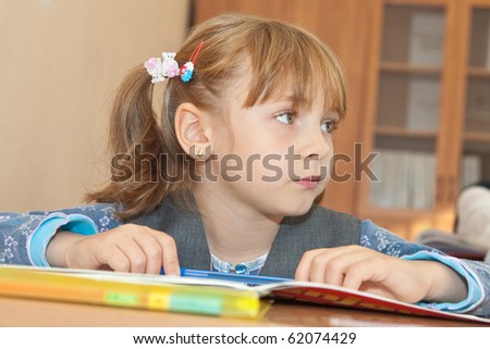 Thoughtful schoolgirl sitting at the desk