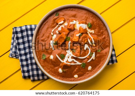Paneer Butter Masala or Cheese Cottage Curry, popular Indian Lunch/Dinner menu  served in a ceramic bowl with Naan Or Roti over moody background, selective focus Royalty-Free Stock Photo #620764175