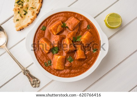 Paneer Butter Masala or Cheese Cottage Curry, popular Indian Lunch/Dinner menu  served with Naan Or Roti over moody background, selective focus Royalty-Free Stock Photo #620766416