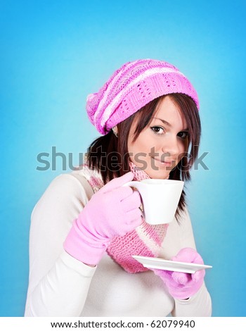 smiling winter  girl with tea on blue background