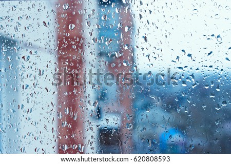 Background image of a rain texture on a window pane. Textured background of a window viewing on the street in drops of pouring rain. Wallpaper texture of water drops