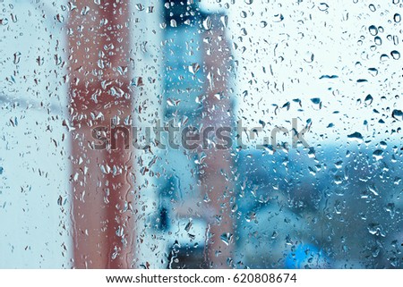 Background image of a rain texture on a window pane. Textured background of a window viewing on the street in drops of pouring rain. Wallpaper texture of water drops
