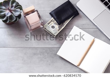 Woman workplace from above. Open notebook, laptop, wallet, perfume. Saving, earning, making money, freelance concept. Copyspace