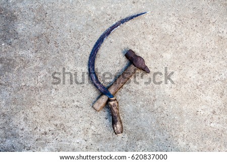 Sickle and hammer (serp i molot). Communist symbol. Farm and worker tools on the concrete surface. Royalty-Free Stock Photo #620837000