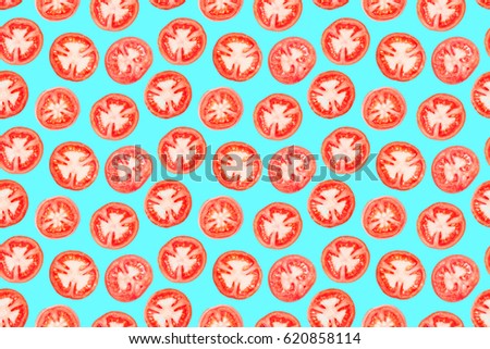 Ripe juicy tomato slices photographic pattern. Isolated on aquamarine background without shadow. Repetitive pattern of tomato pieces on aquamarine underlay. Fresh shiny cuts of love apples