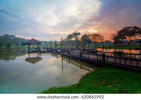 Sunrise at lake with clouds over the sky at Tasik Ilmu UTM Skudai Johor Malaysia. This image may contain noise ,blurry clouds due to long exposure, soft focus and poor lighting