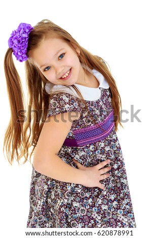 Happy little girl with a big purple bow on her head , and fancy dress. The girl bent her head to see her long beautiful hair.Isolated on white background.