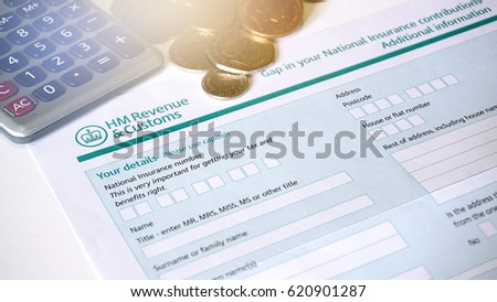 Photo of filling in a HM customs form a personal details for UK self assessment tax and benefits right. Royalty-Free Stock Photo #620901287