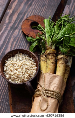 raw horseradish roots on wooden background. horseradish with leaves.Homemade wassabi.Top view