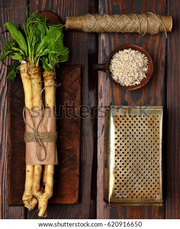 raw horseradish roots on wooden background. horseradish with leaves.Homemade wassabi.Top view