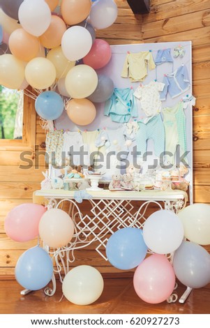 Decoration of the table with gentle tones and shades with a lot of colorful balloons