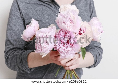 Woman holding pink peonies.