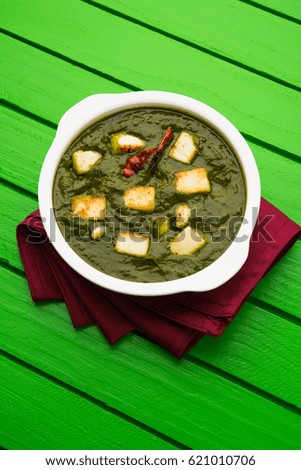 Palak Paneer Curry made up of spinach and cottage cheese, Popular Indian healthy Lunch/Dinner food menu, served in a bowl with Roti Or Chapati over moody background. selective focus