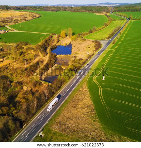 Aerial view of highway going through countryside in hot sunset evening. Landscape aerial photography.