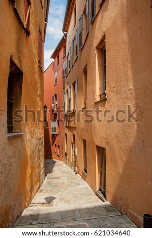 View of narrow alley and buildings with shops in the city center of Grasse, known for producing perfumes. Located in the Alpes-Maritimes department, Provence region, southeastern France
