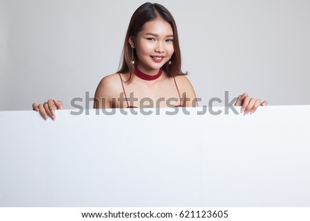 Young Asian woman with blank sign on gray background