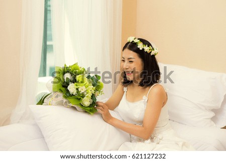Happy woman with flowers on the bedroom 