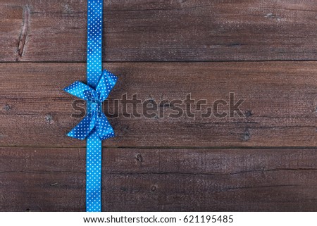 Old wooden background with beautiful bow on a line with copy space. Flat lay.
