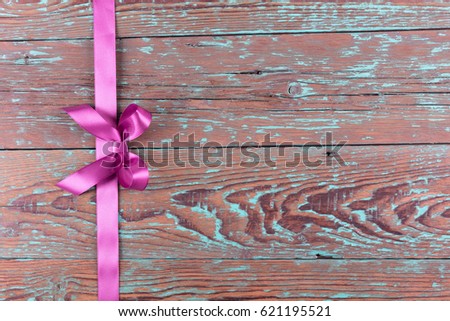 Old wooden background of brushed in blue planks with beautiful bow on a line. Flat lay.