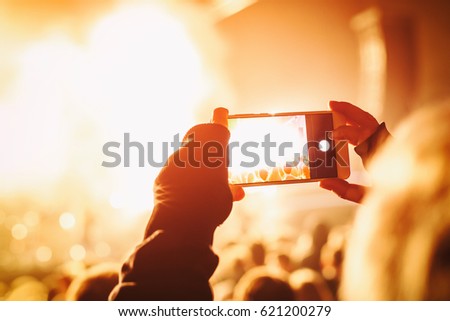 Hands with a smartphone records live music festival, live concert, show on stage