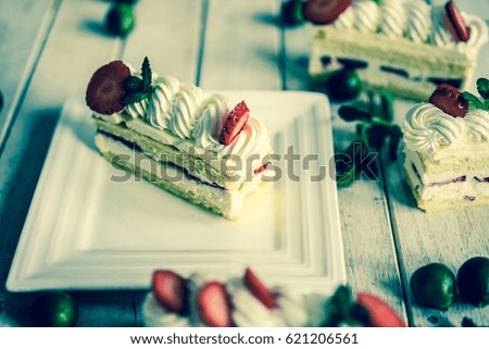 Cream cake with strawberries and Mint Leaves on rustic background.