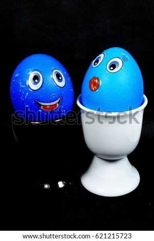 Two Funny eggs with eyes and moustache in the eggcup (Happy Easter) isolated on the black background