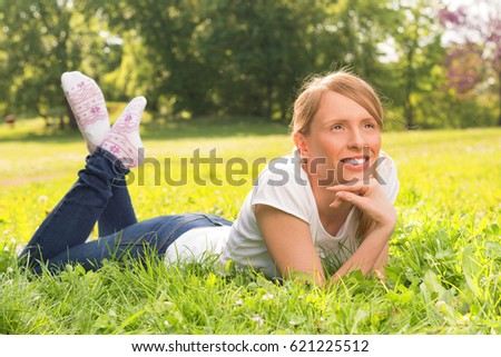 Friendly looking woman with the smile on her face  lying down and looking up.