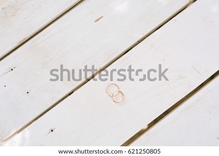 Wedding rings on a white wooden texture. Wedding jewelry.