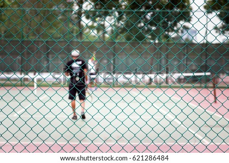Tennis court behind fence mesh netting