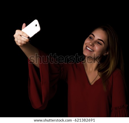 Pretty girl makes selfie Black background